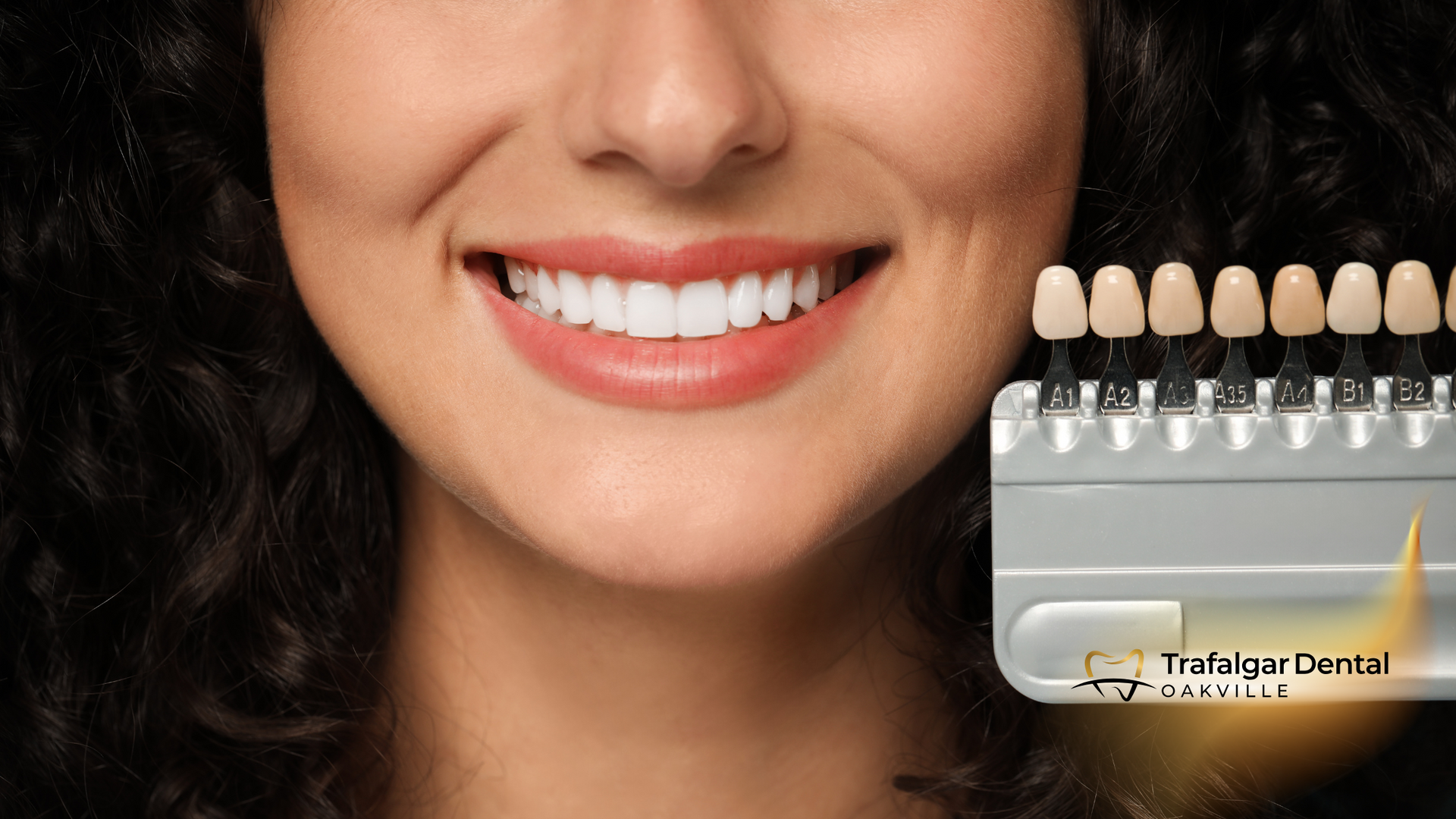 A close up of a woman 's smile next to a tooth color chart.