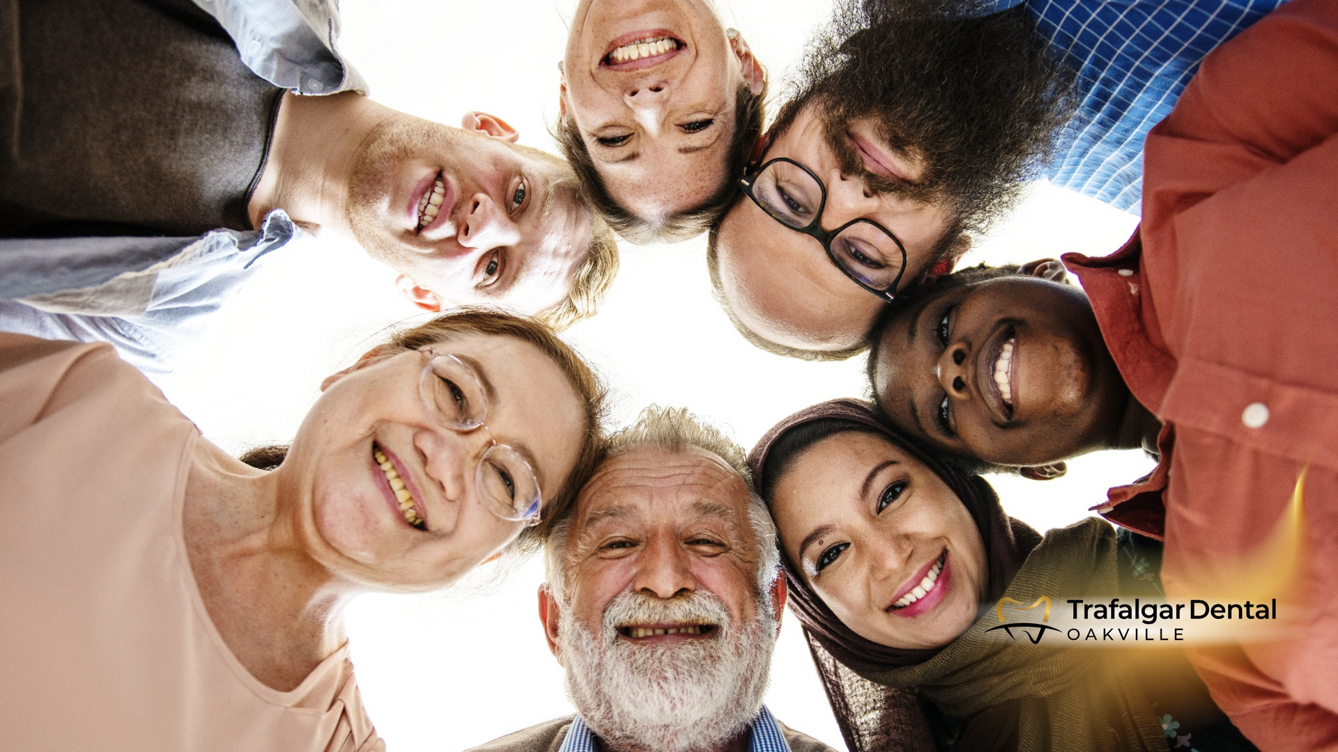 A group of people are standing in a circle and smiling.