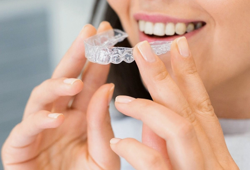 A woman is getting her teeth examined by a dentist.
