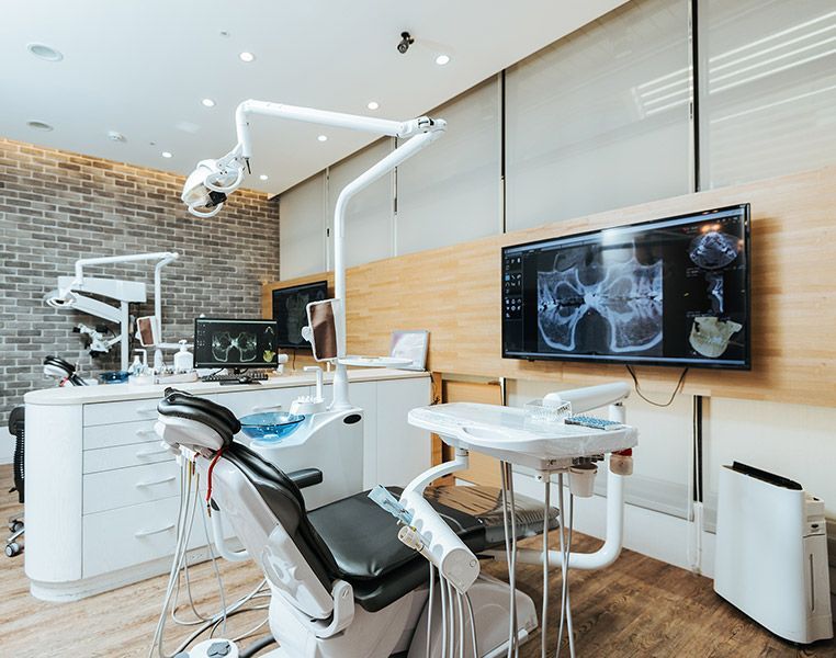 A dental office with a dental chair and a television on the wall.