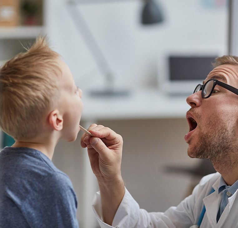 Man checking child's teeth
