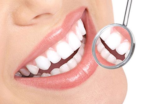 A woman is getting her teeth examined by a dentist.