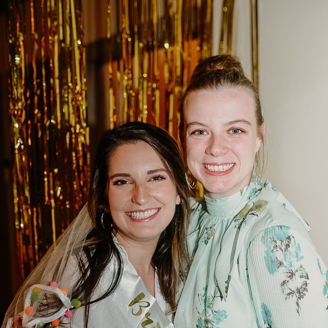 Two women are posing for a picture together at a bridal shower.