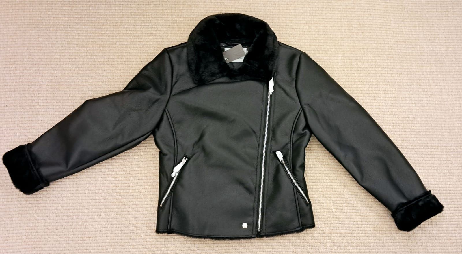 Una mujer lleva una chaqueta negra con cuello de piel.