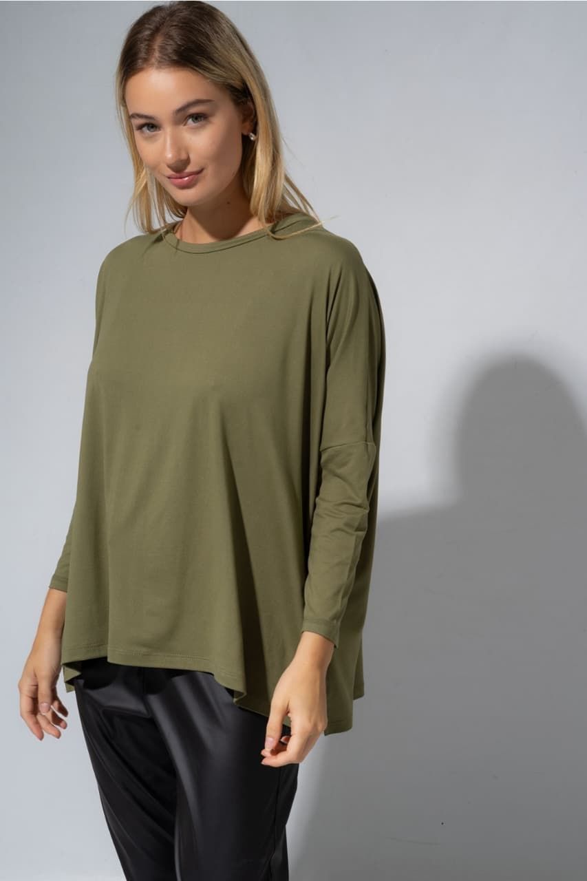 Una mujer lleva una camisa blanca y pantalones negros.