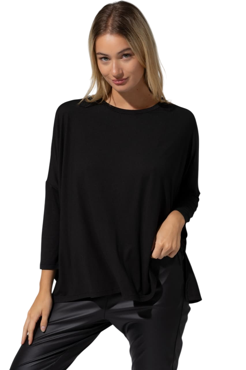 Una mujer lleva una camisa negra y pantalones negros.