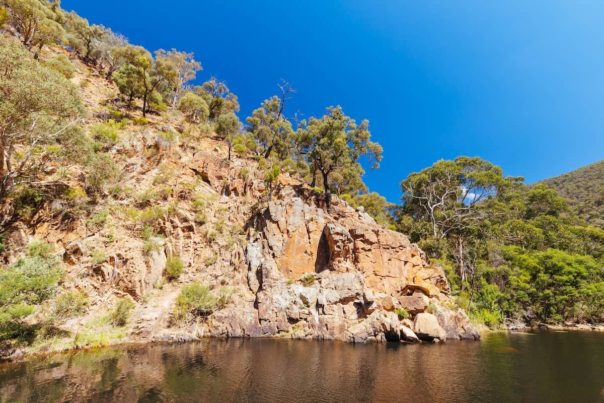 a Lake Surrounded by Rocks and Trees With a Blue Sky in the Background — Armstrong Locksmiths Ballarat in Bacchus Marsh, VIC