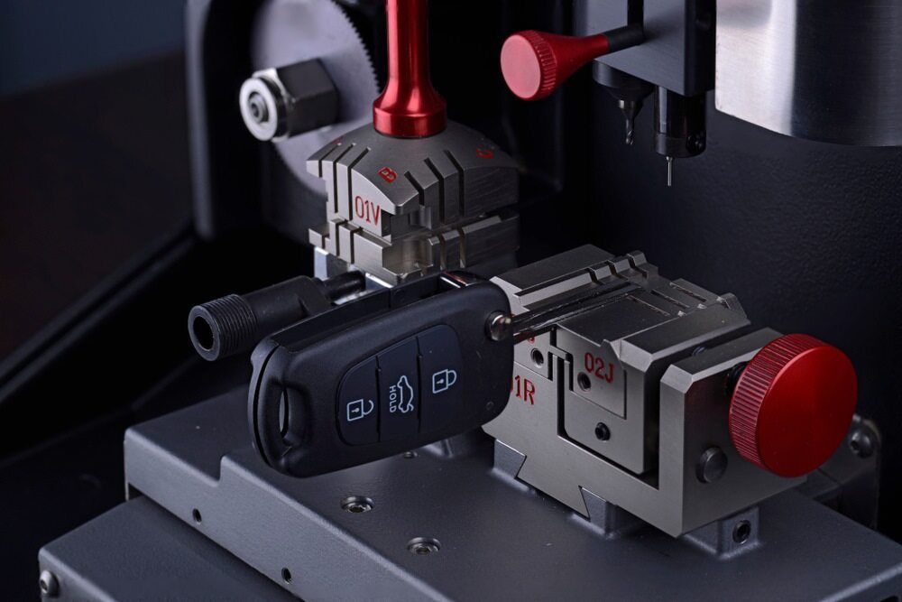 Black Modern Car Key in Locksmith Cutting Machine — Armstrong Locksmiths Ballarat in Ballarat East, VIC