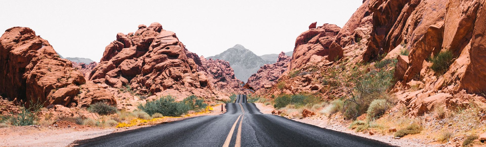 A road in the middle of a desert surrounded by rocks.
