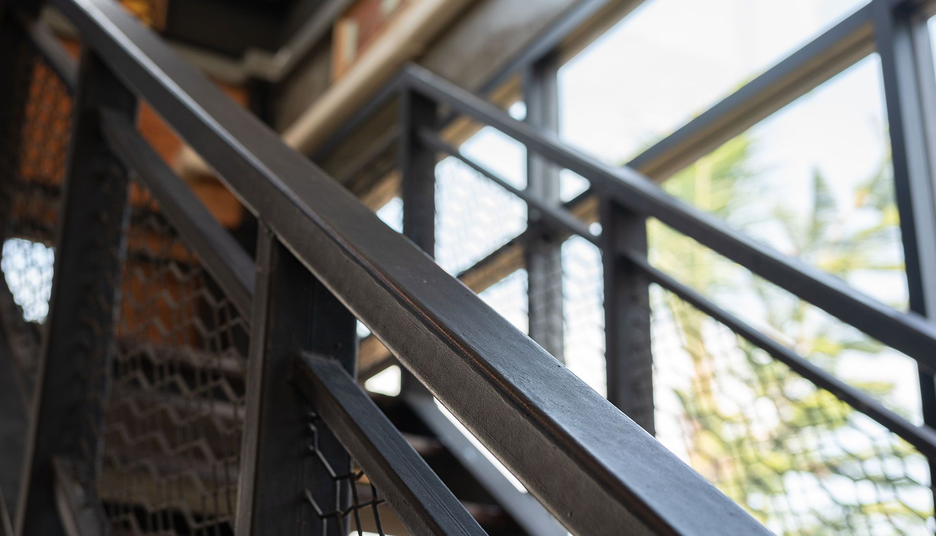 Black metal staircase with handrail, close-up view.