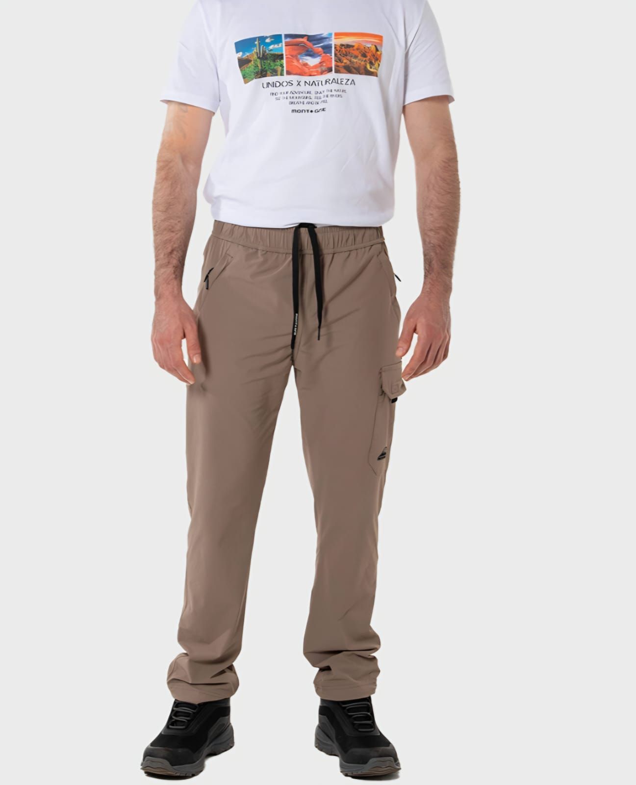Hombre de pie, vestido con una camiseta blanca estampada y pantalones cargo color beige.