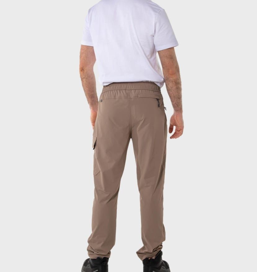 Hombre vestido con pantalones negros y camisa blanca, de pie, con zapatos negros y verde azulado.