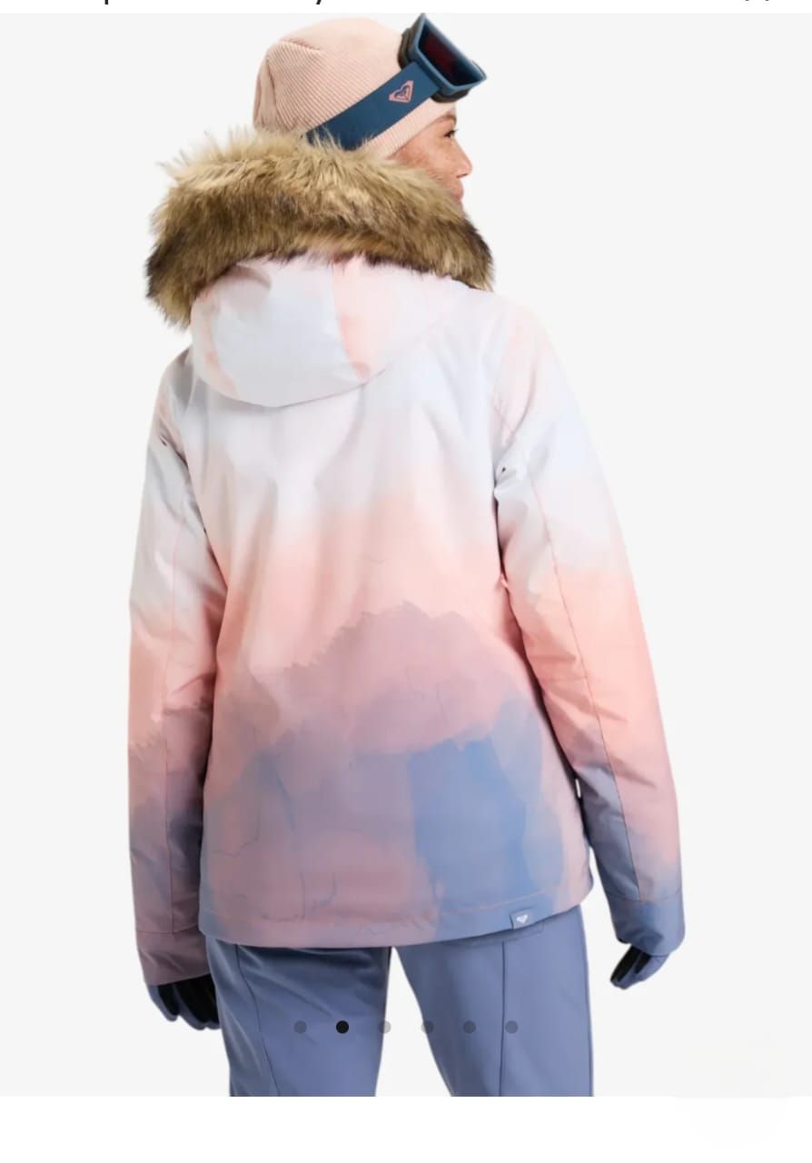 Mujer vestida con ropa de esquí, sonriendo