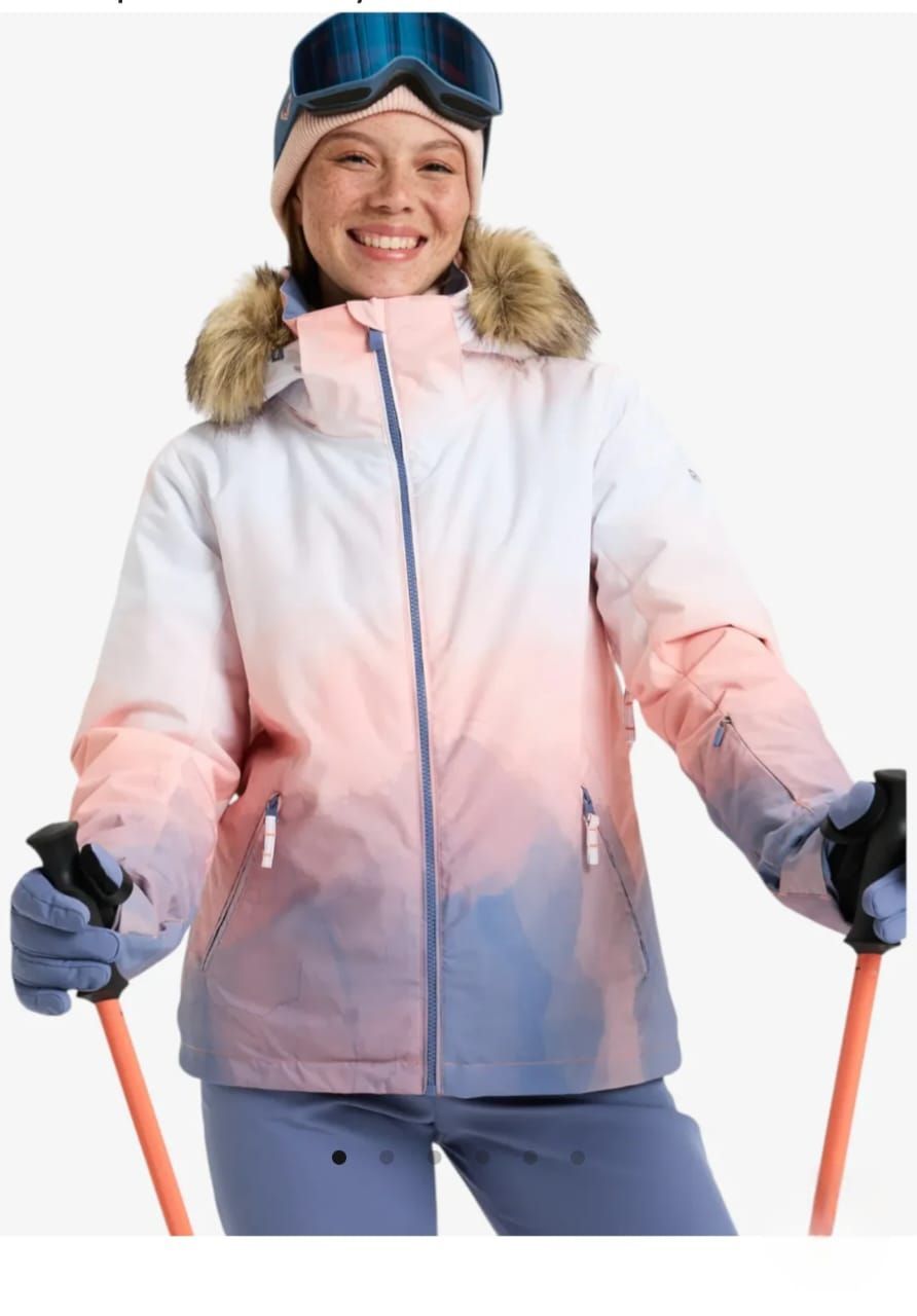 Mujer vestida con ropa de esquí, sonriendo