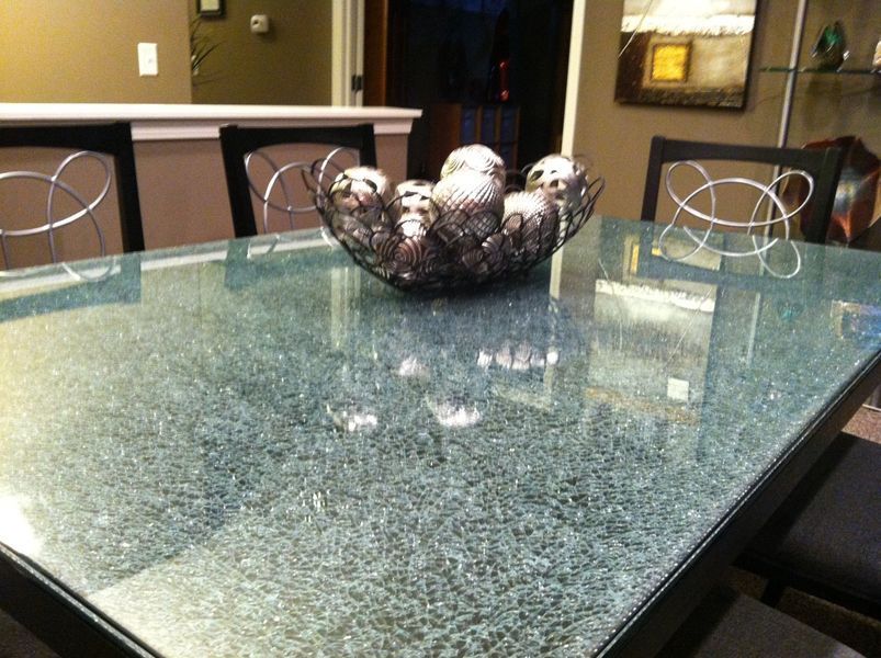 A glass table with a bowl of balls on it