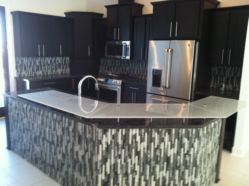 A kitchen with black cabinets and stainless steel appliances