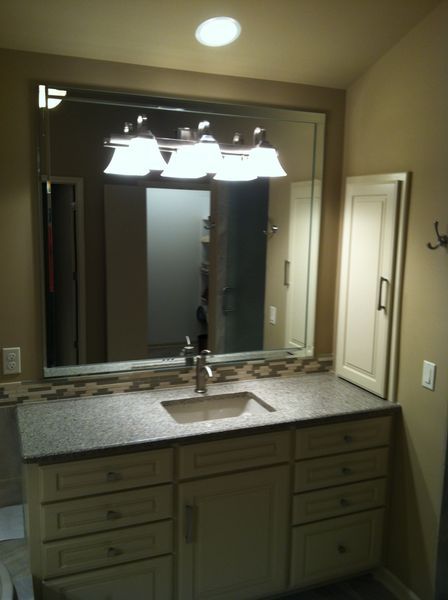 A bathroom with a sink and a large mirror