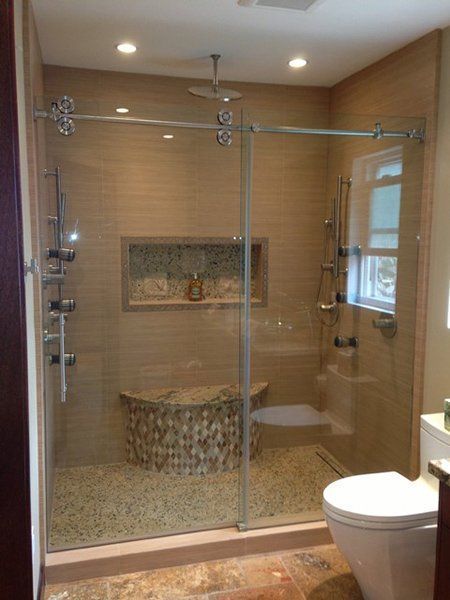 A bathroom with a sliding glass shower door and a toilet.