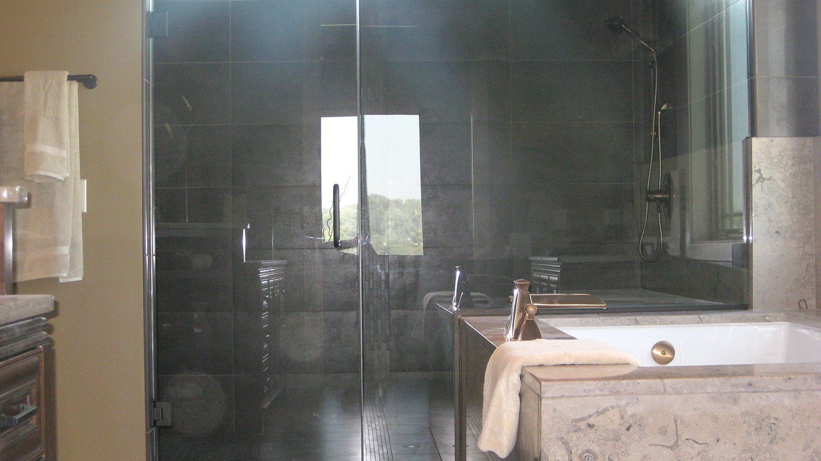 A bathroom with a bathtub , sink , and shower.