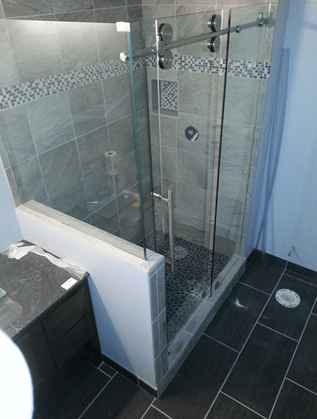 A bathroom with a sliding glass shower door