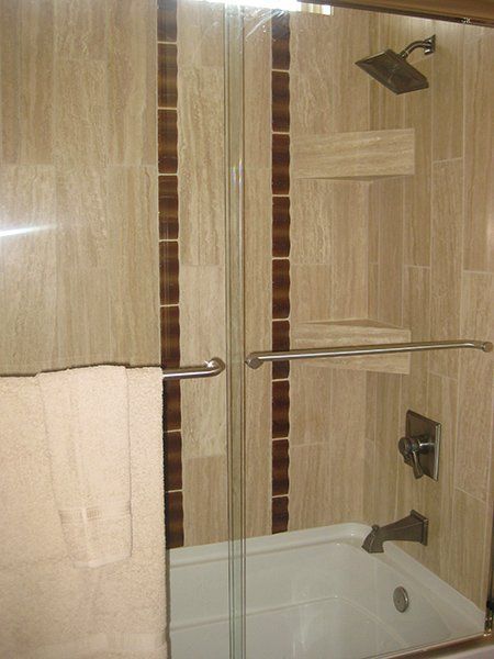 A bathroom with a tub and a shower with a sliding glass door