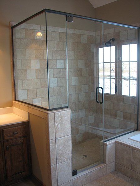A bathroom with a walk in shower and a window