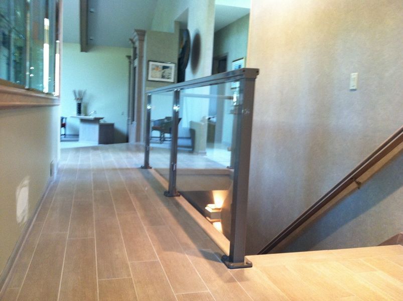 A hallway with stairs and a glass railing