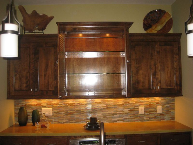 A kitchen with wooden cabinets and a stone wall