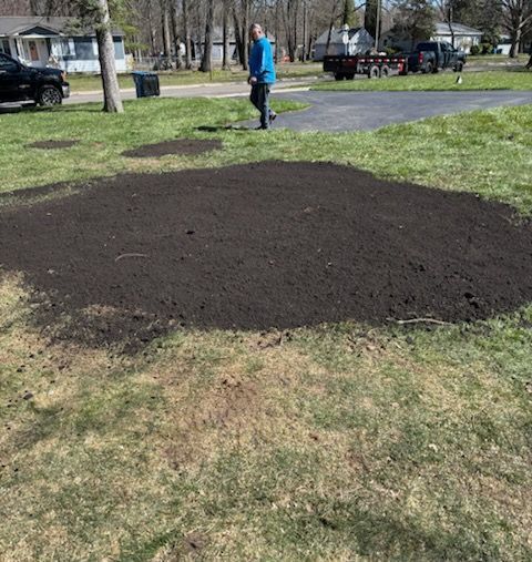 A truck is parked in a dirt field next to a pile of dirt.
