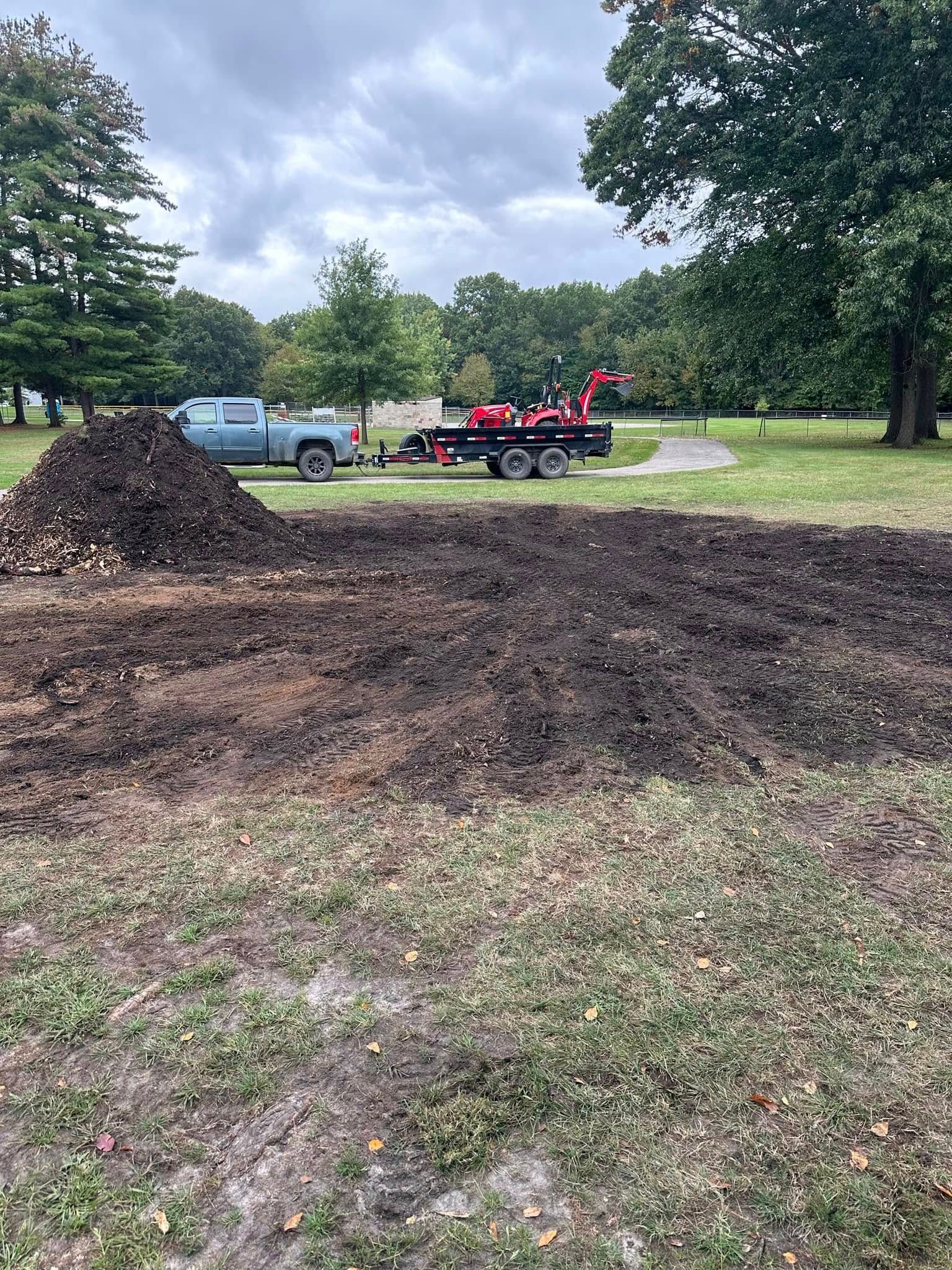 A truck is parked in a dirt field next to a pile of dirt.