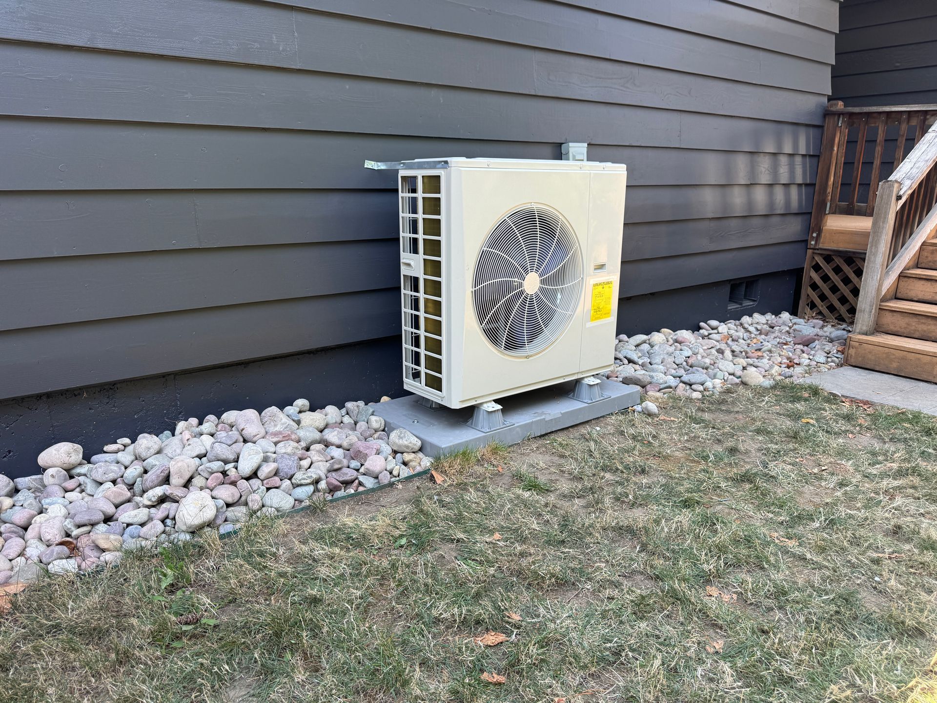 new Carrier heat pump outdoor unit installed on a pad at a Tacoma home