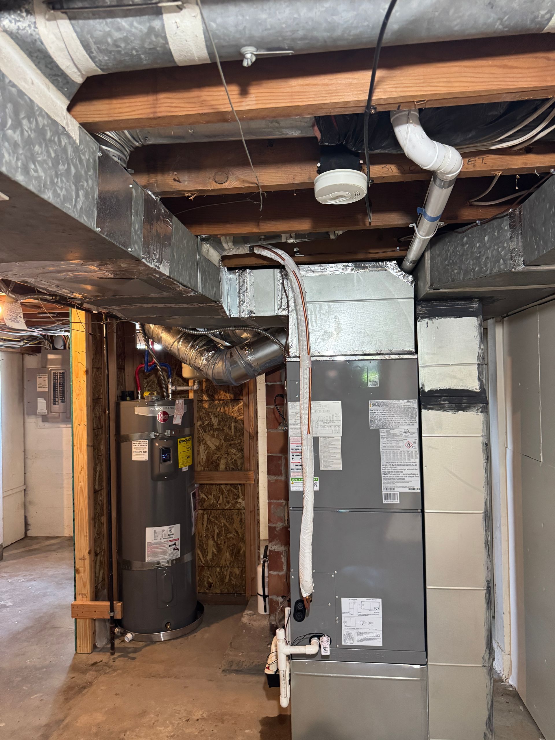 new Carrier electric air handler with custom metal ductwork transition in a Tacoma basement