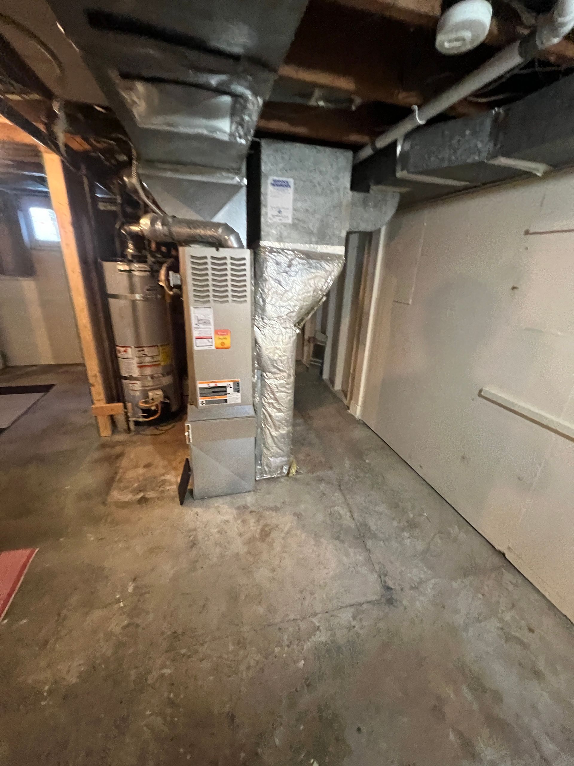 old gas furnace with offset ductwork in a Tacoma utility room before replacement