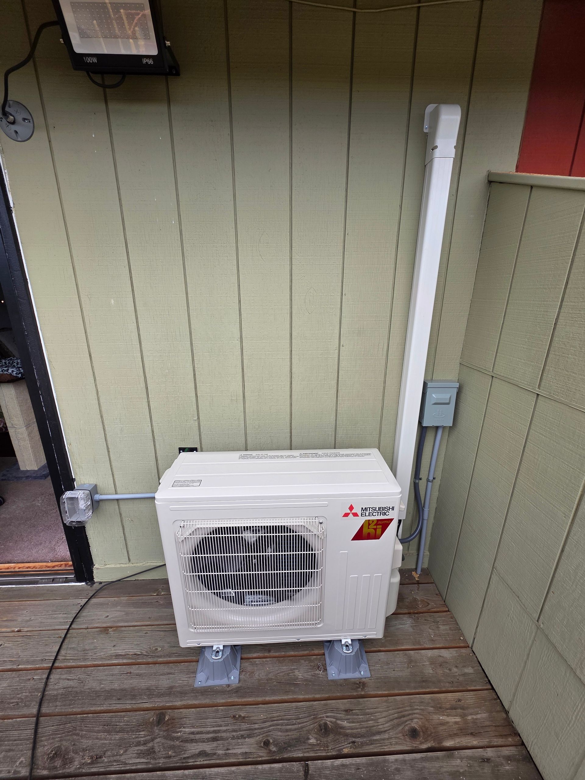 Mitsubishi H2i Hyper-Heat outdoor ductless unit installed on a wooden deck in Federal Way