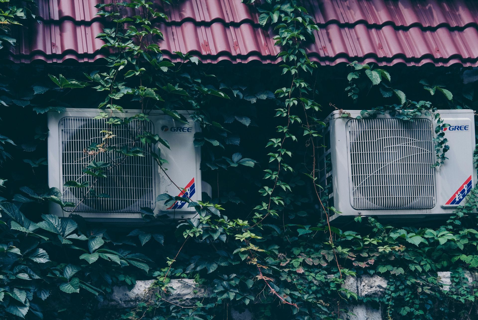 There are two air conditioners on the side of a building.
