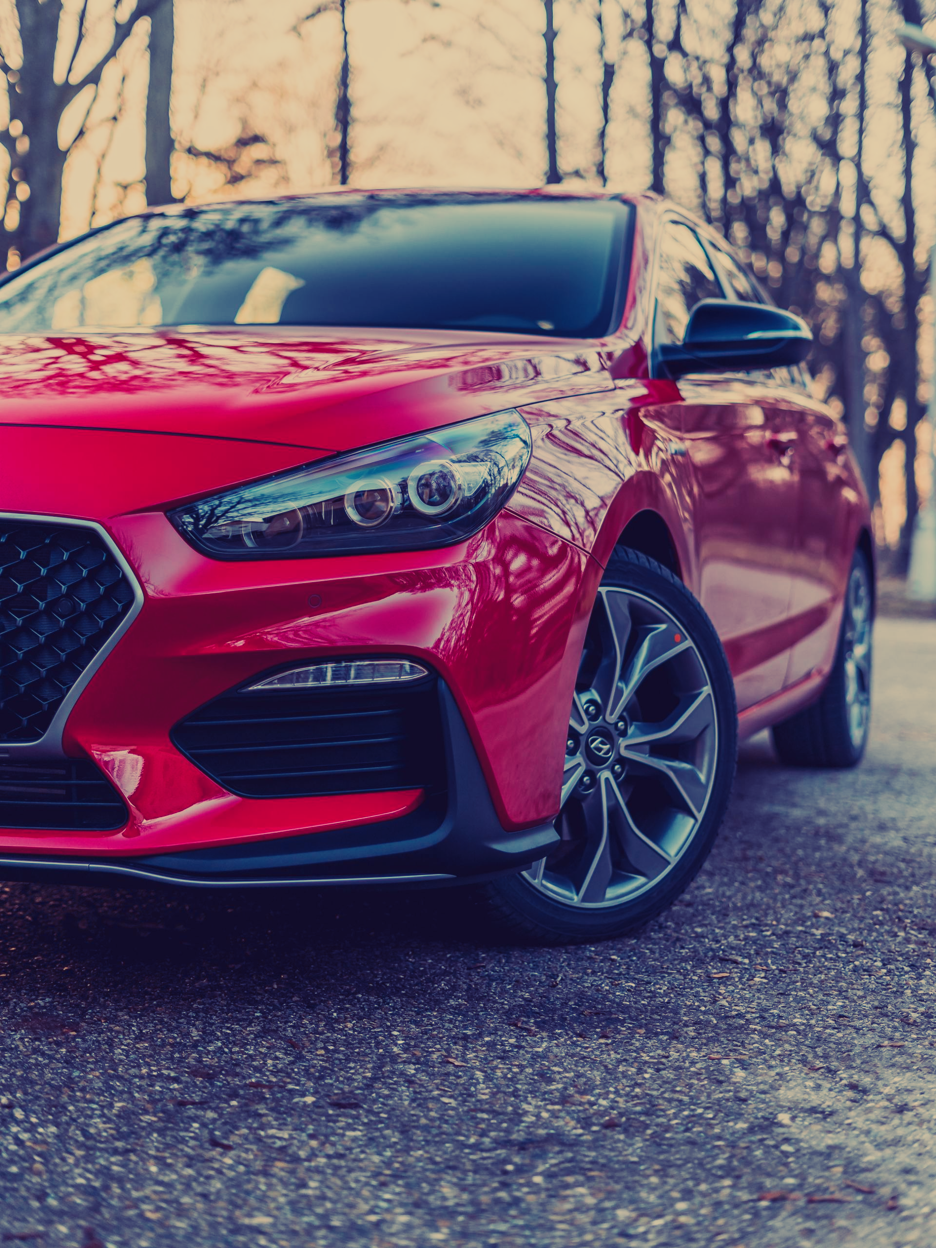 A red car is parked on the side of the road