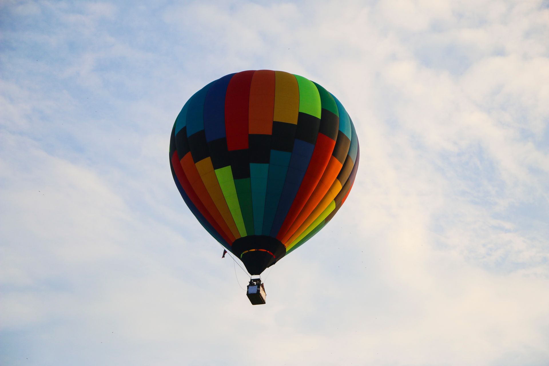 A colorful hot air balloon is flying in the sky