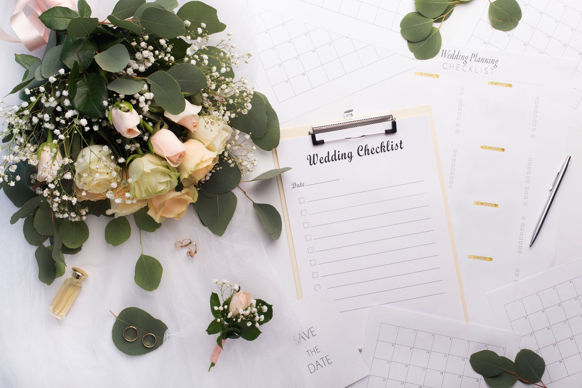 A wedding checklist is sitting on a table next to a bouquet of flowers.