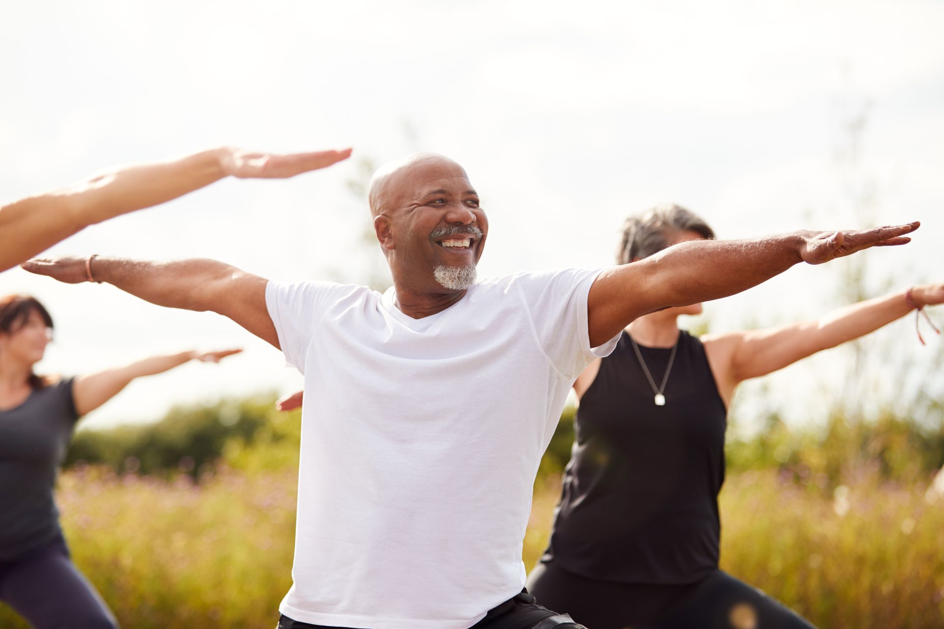 A group of people are practicing yoga in a field.