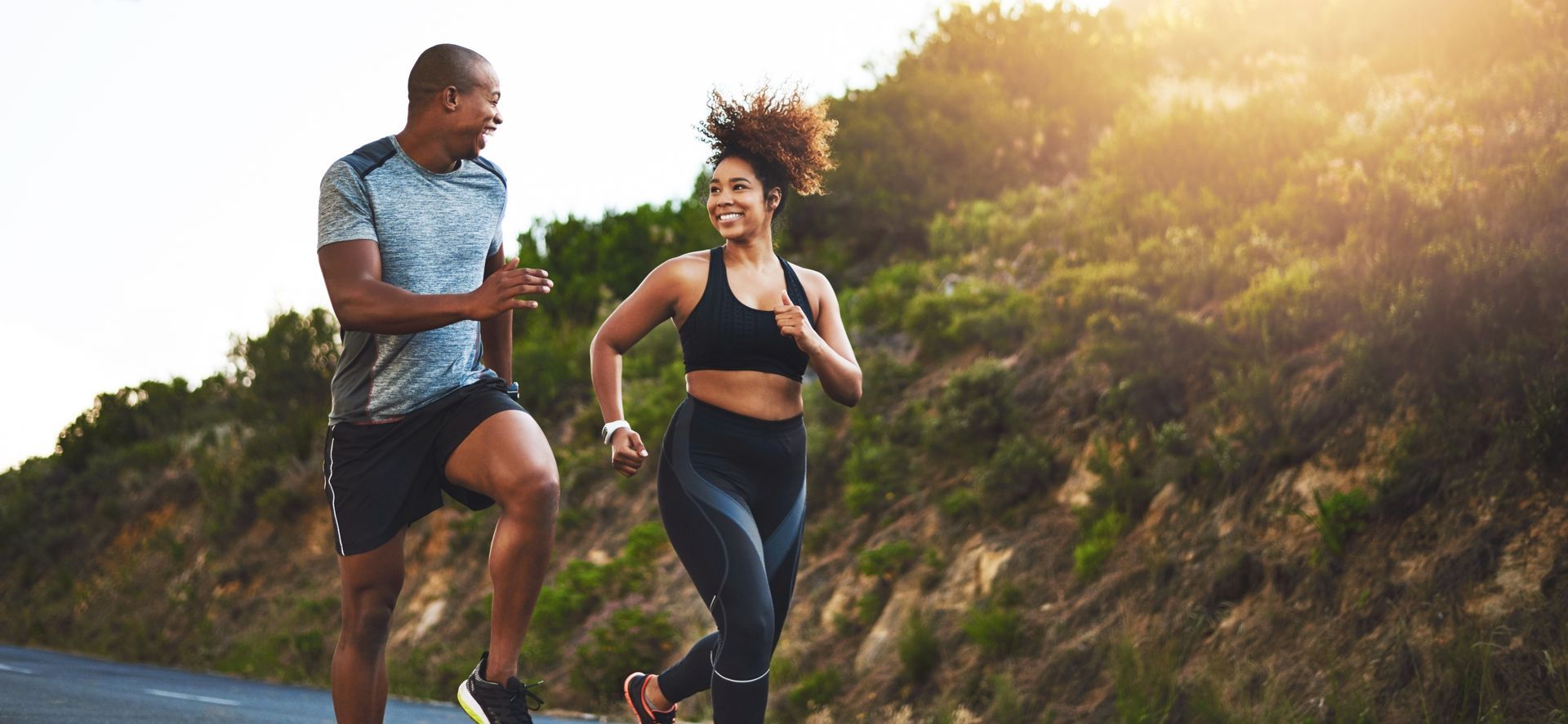 A man and a woman are running on a road.