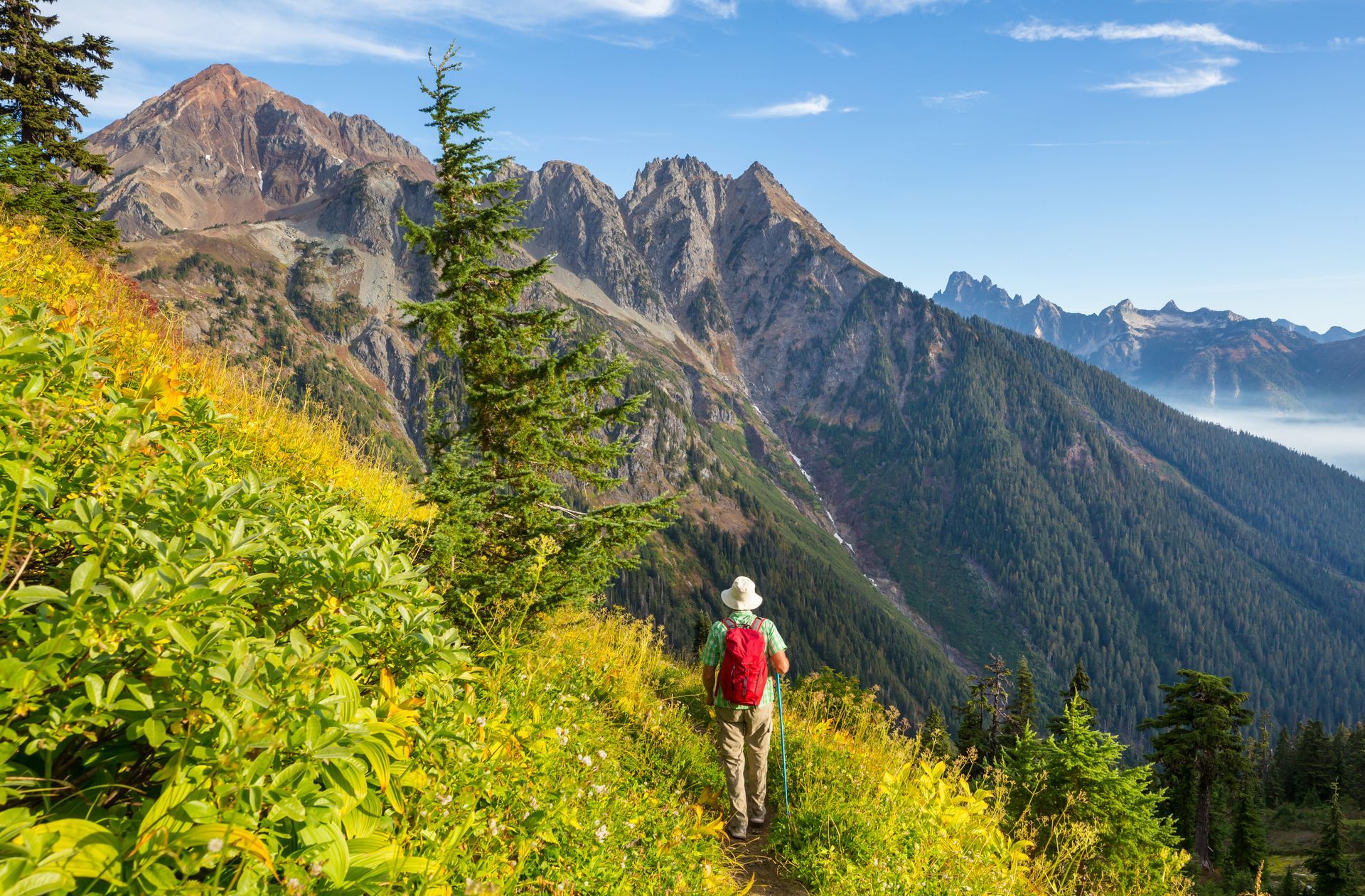 A person is hiking on a trail in the mountains.