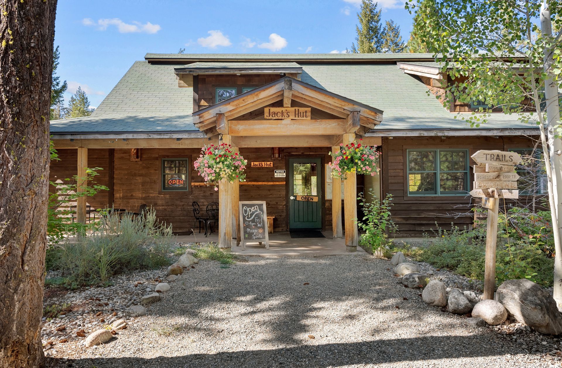 A plate of sliders and a glass of beer on a wooden table.