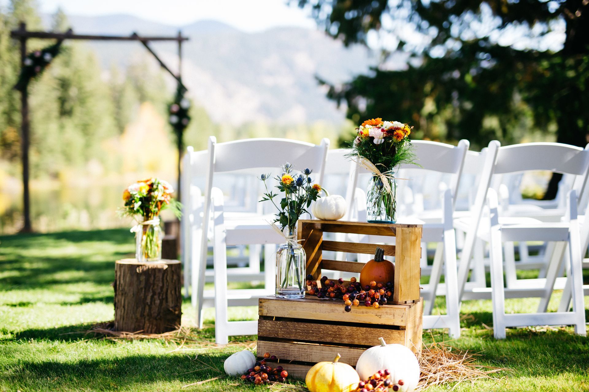 A row of white chairs sitting on top of a lush green field.