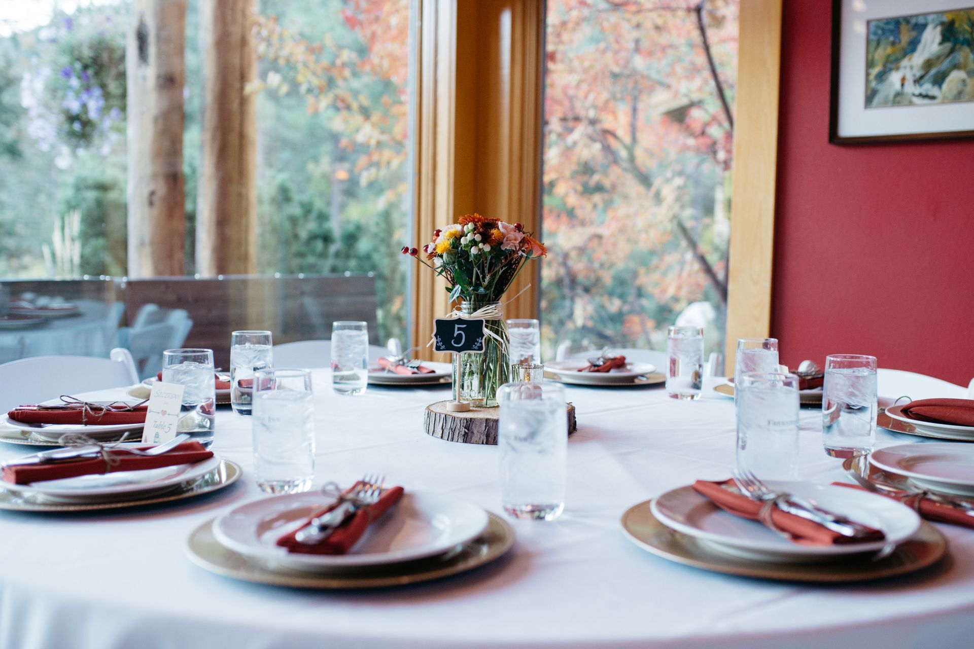 A table set for a wedding reception with plates , glasses , and napkins.
