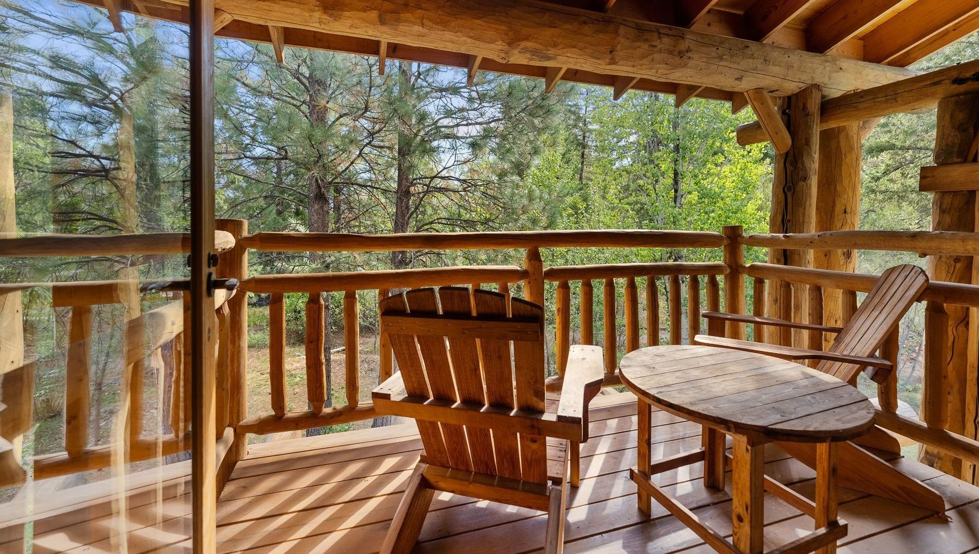 There is a wooden deck with a table and chairs on it.