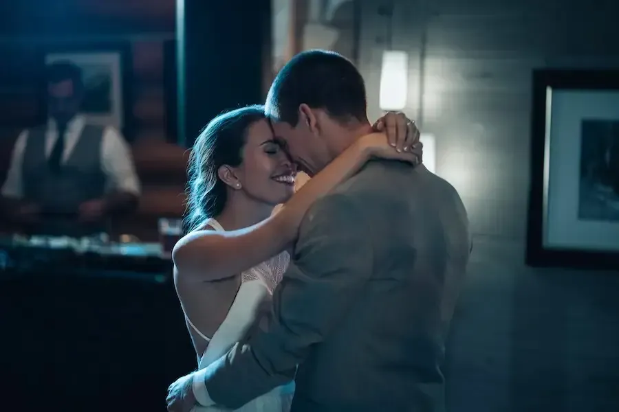A bride and groom are dancing together at their wedding reception.