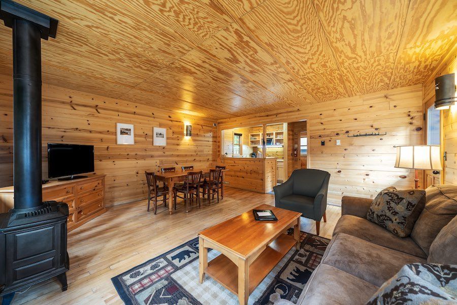 A living room with a couch , chair , table and television.