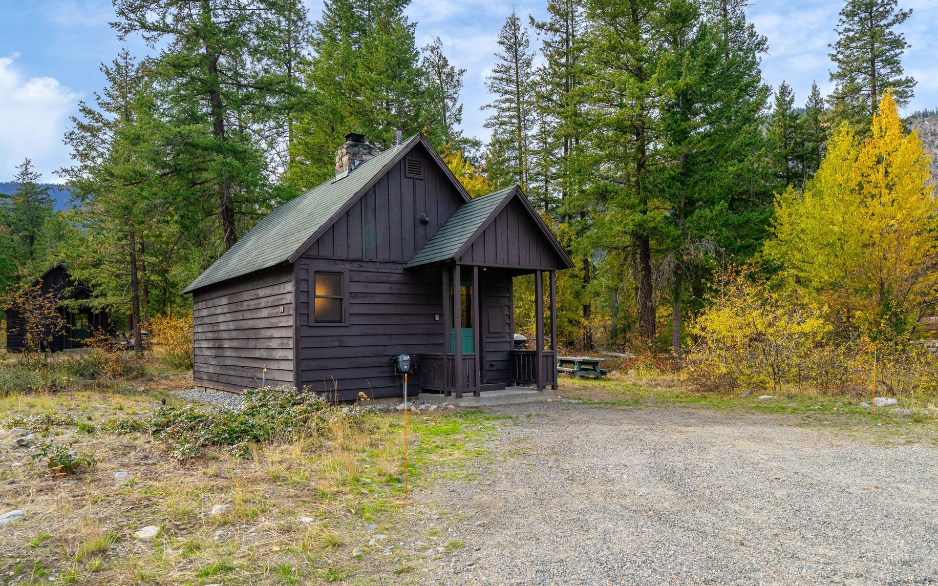 A small log cabin in the middle of a forest.