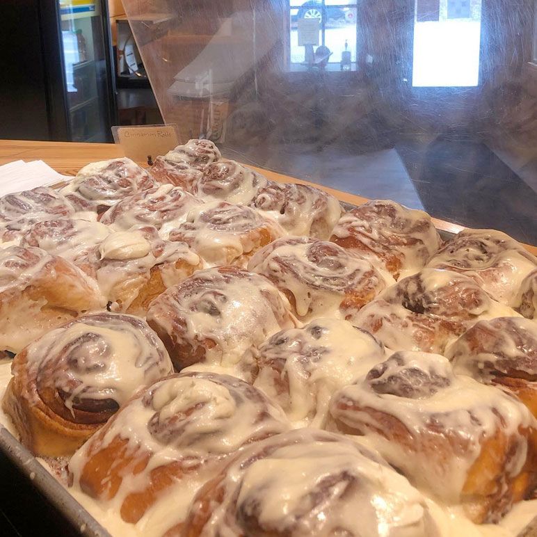 A tray of cinnamon rolls with icing on them
