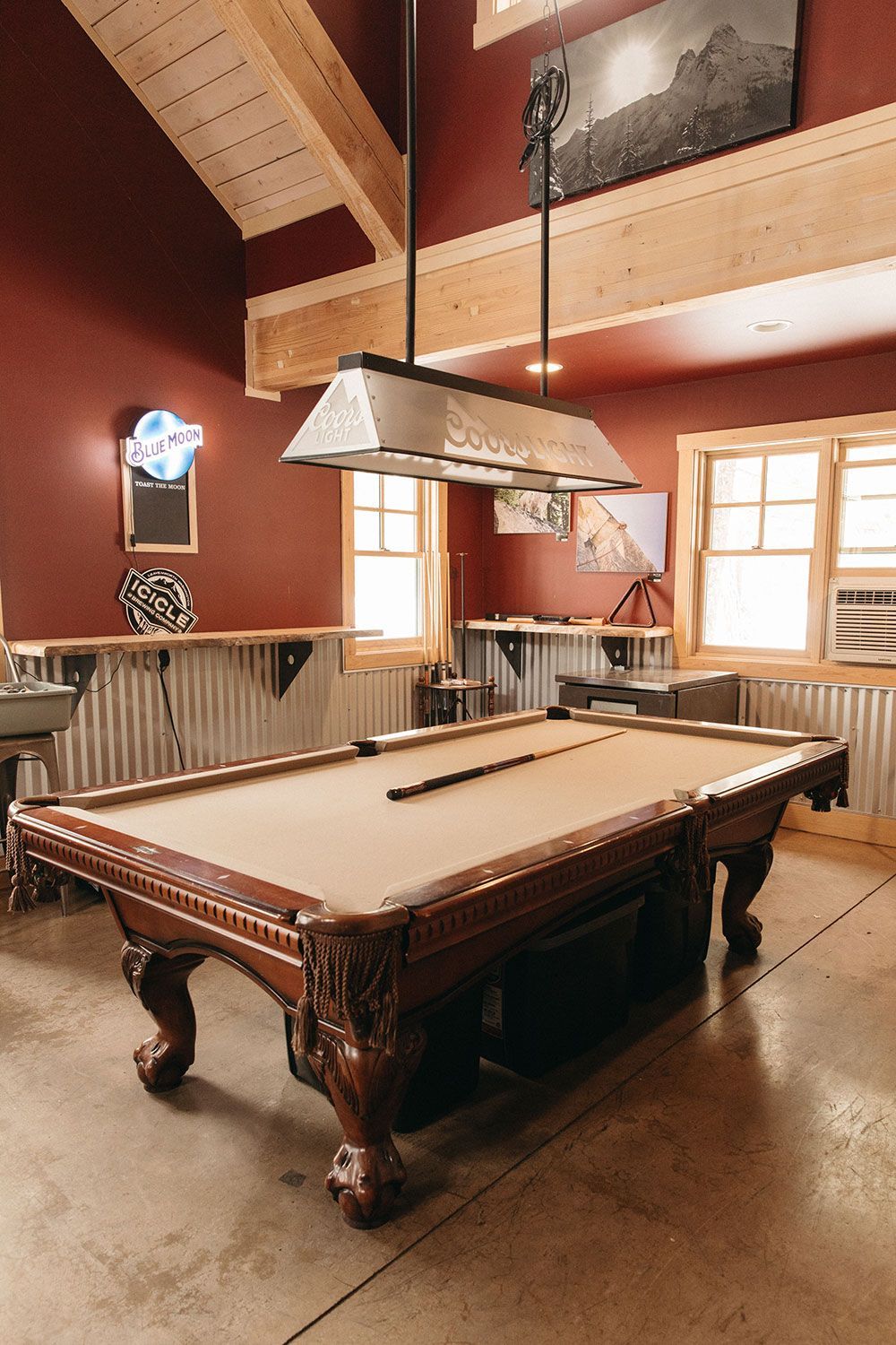 A pool table is sitting in a room with red walls.